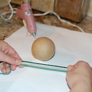 Yarn end glued to a foam ball to begin the ornament