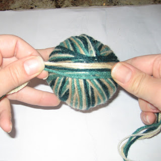 Yarn strands positioned across the top of a wrapped yarn ball