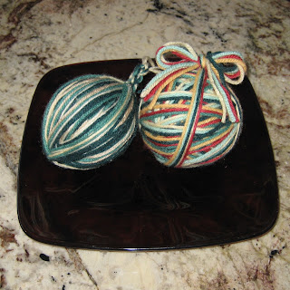 Two handmade yarn ball ornaments ready for the Christmas tree