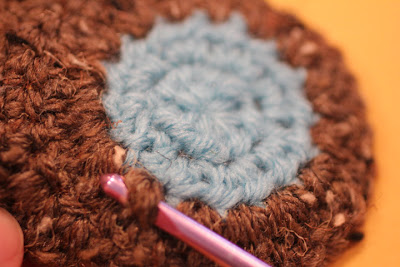Crochet hook positioned behind the owl motif for attaching chain loops