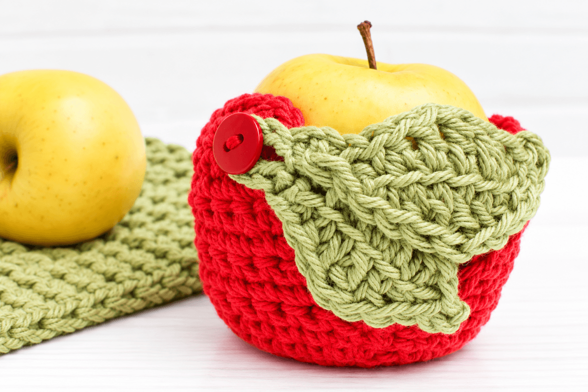 Red and green crochet apple cozy with leaf closure