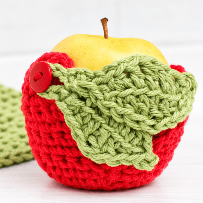 Red and green crochet apple cozy with leaf closure