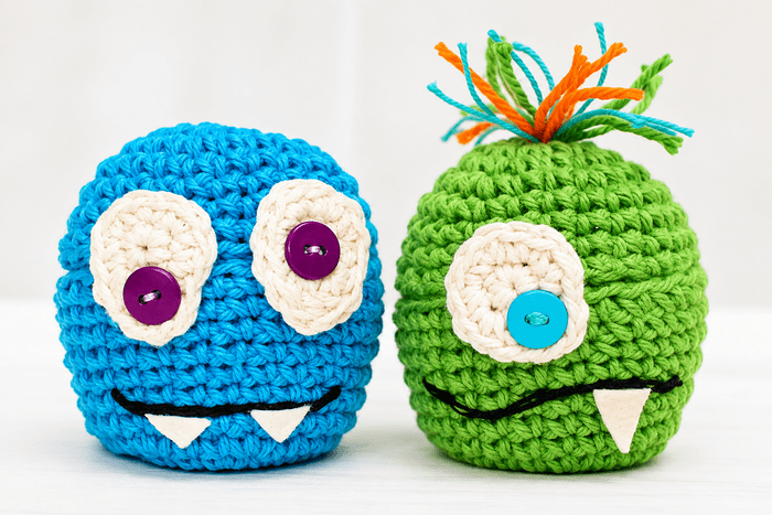 Green and blue crochet monster apple cozies