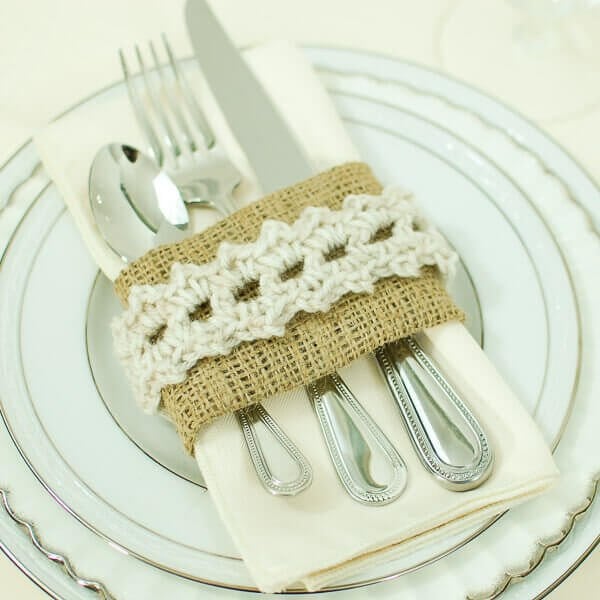 Crochet-trimmed burlap place setting holding a napkin and silverware