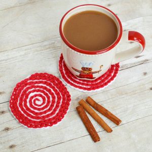 These Peppermint Swirl Coasters are perfect for adding holiday charm to your home or for gifting. Work up a set and pair it with some gourmet hot chocolate mix and marshmallows and you have a great gift set! www.petalstopicots.com #crochet #pattern #Christmas #holiday