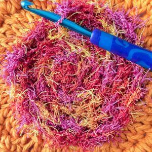 crocheting surface stitches of scrubby yarn to the center