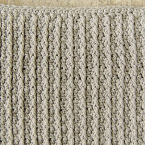 The Cabled Columns dishcloth features deeply textured accent columns produced by double crochet post stitches alternating with regular double crochet stitches on right side rows, while working single crochet stitches only on wrong side rows. 