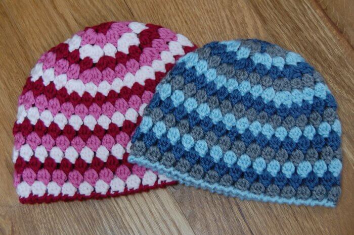 Three yarn colors are used to crochet both the child and the toddler hat sizes.