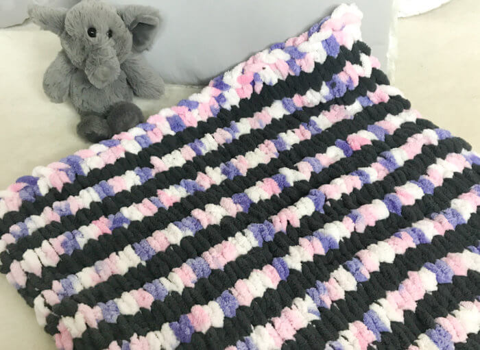 This loop yarn blanket as written here measures approximately 21 x 26 in. It's the perfect size for a newborn or to use as a car seat blanket.