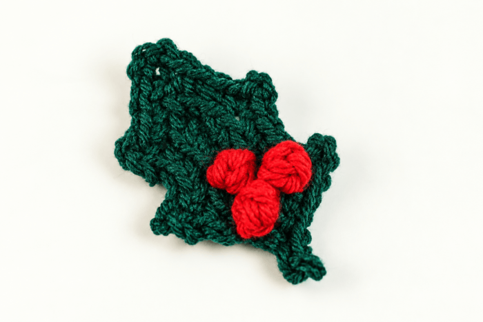 Green crochet holly leaf with three red berries